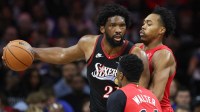 Philadelphia 76ers center Joel Embiid (21) controls the ball against Toronto Raptors forward Scottie Barnes (4) and guard Ja'Kobe Walter (14) during the third quarter at Xfinity Mobile Arena