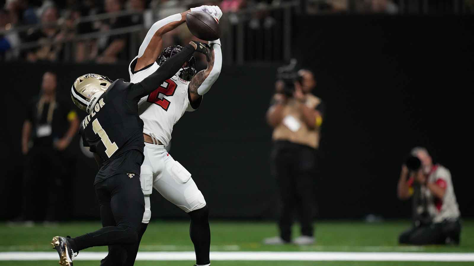 Tampa Bay Buccaneers wide receiver Emeka Egbuka (2) catches a pass under pressure from New Orleans Saints cornerback Alontae Taylor (1) during the fourth quarter at Caesars Superdome.