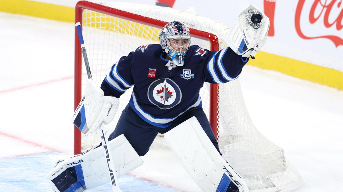 Winnipeg Jets goaltender Eric Comrie (1) makes a glove save against the Carolina Hurricanes in the first period at Canada Life Centre.