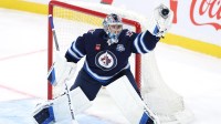 Winnipeg Jets goaltender Eric Comrie (1) makes a glove save against the Carolina Hurricanes in the first period at Canada Life Centre.
