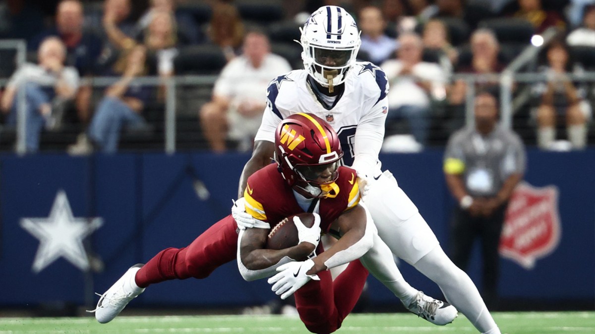 Dallas Cowboys cornerback Kaiir Elam (20) tackles Washington Commanders running back Jacory Croskey-Merritt (22) during the first quarter of the game at AT&T Stadium.