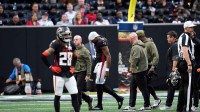 Atlanta Falcons quarterback Michael Penix Jr. (9) is escorted off the field in the second half against the Carolina Panthers at Mercedes-Benz Stadium.