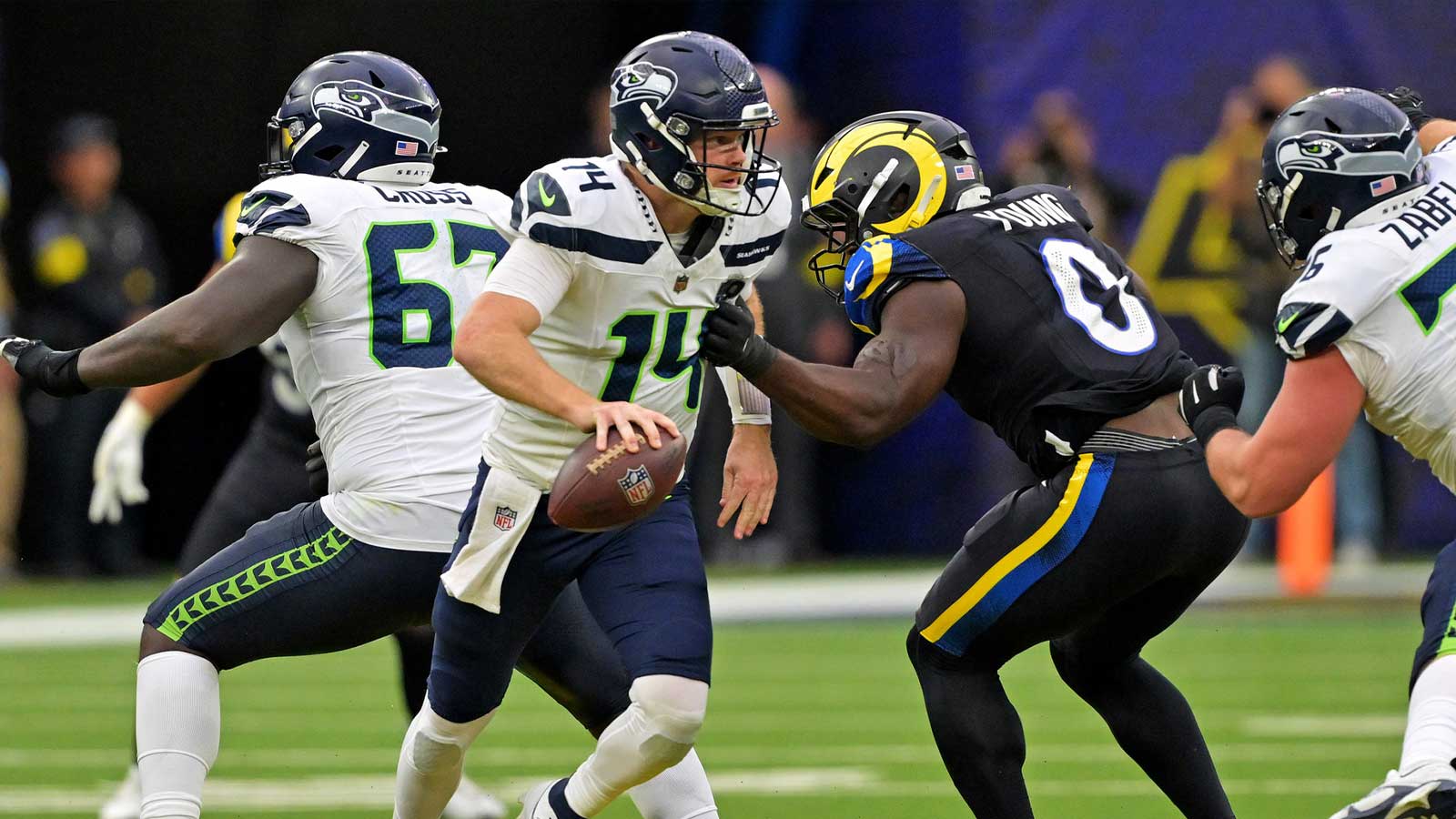 Seattle Seahawks quarterback Sam Darnold (14) runs away from Los Angeles Rams linebacker Byron Young (0) during the second half at SoFi Stadium.