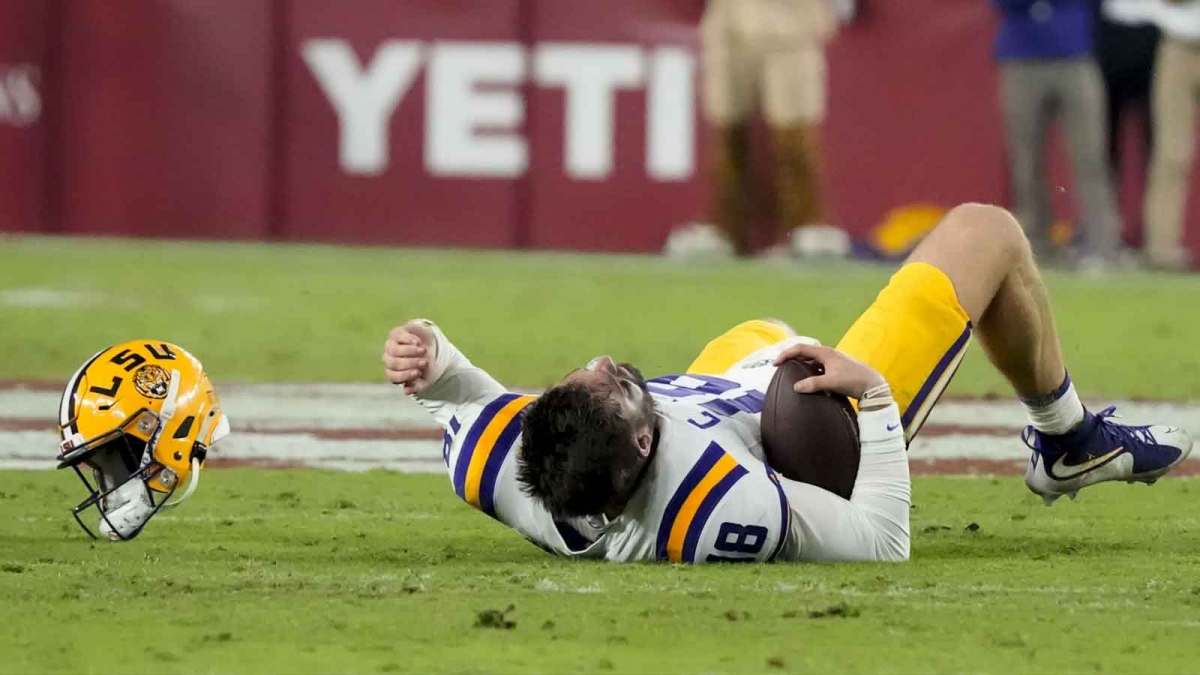 LSU quarterback Garrett Nussmeier (18) has his helmet ripped off when his facemask was pulled by Alabama defensive lineman Jordan Renaud (11) at Saban Field at Bryant-Denny Stadium. Alabama defeated LSU 20-9. Mandatory Credit: Gary Cosby Jr.-Imagn Images