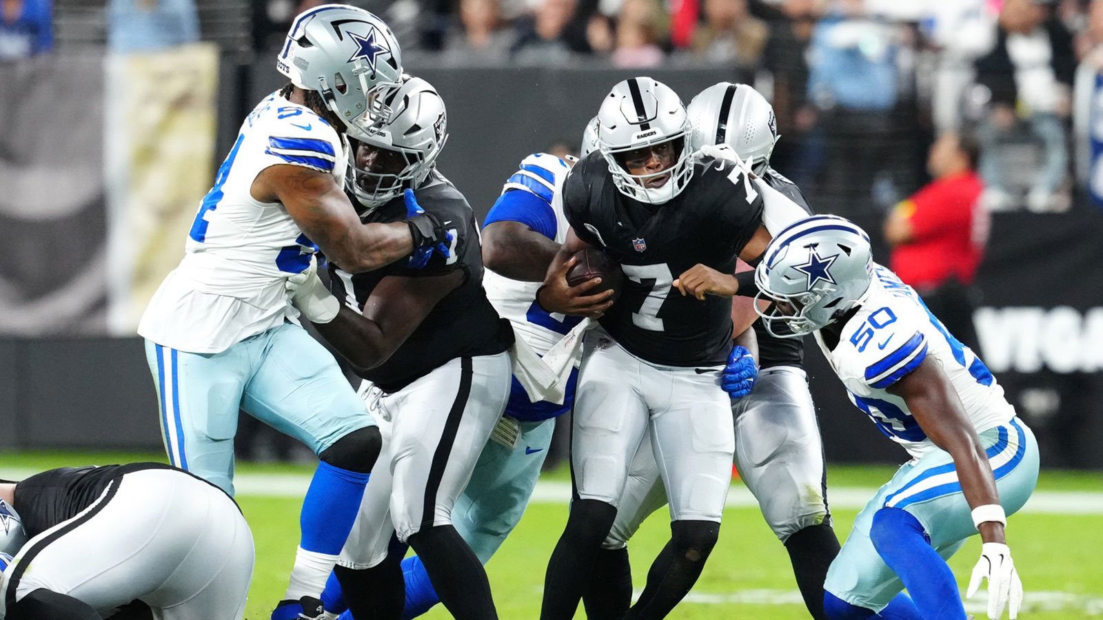 Las Vegas Raiders quarterback Geno Smith (7) is sacked by Dallas Cowboys guard Tyler Booker (52) during the first half at Allegiant Stadium.