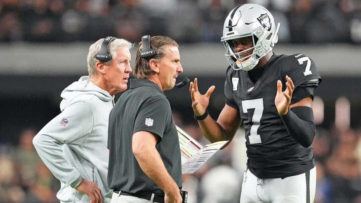 Las Vegas Raiders quarterback Geno Smith (7) talks with head coach Pete Carroll and quarterbacks coach Greg Olsen in a game against the Cleveland Browns during the fourth quarter at Allegiant Stadium.