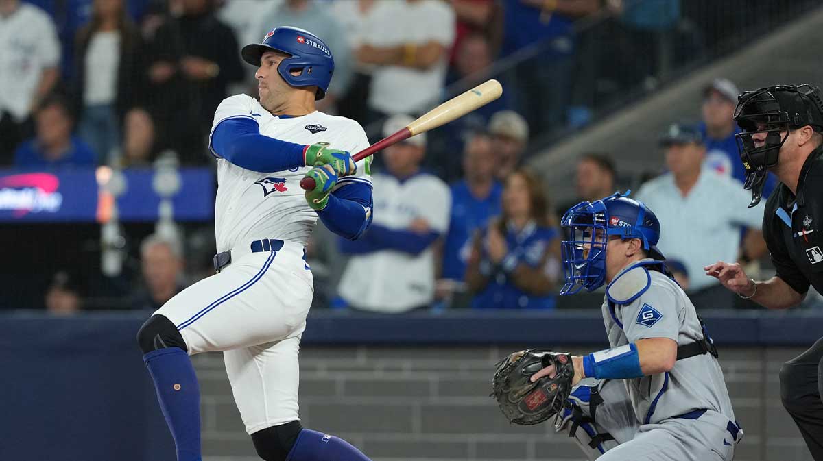 Toronto Blue Jays right fielder George Springer (4) hits a single against the Los Angeles Dodgers in the first inning for game seven of the 2025 MLB World Series at Rogers Centre. 