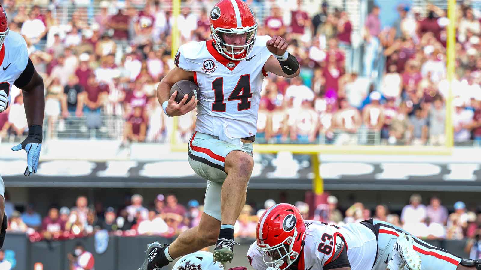 Georgia Bulldogs quarterback Gunner Stockton (14) runs with the ball against the Mississippi State Bulldogs during the first half at Davis Wade Stadium at Scott Field.