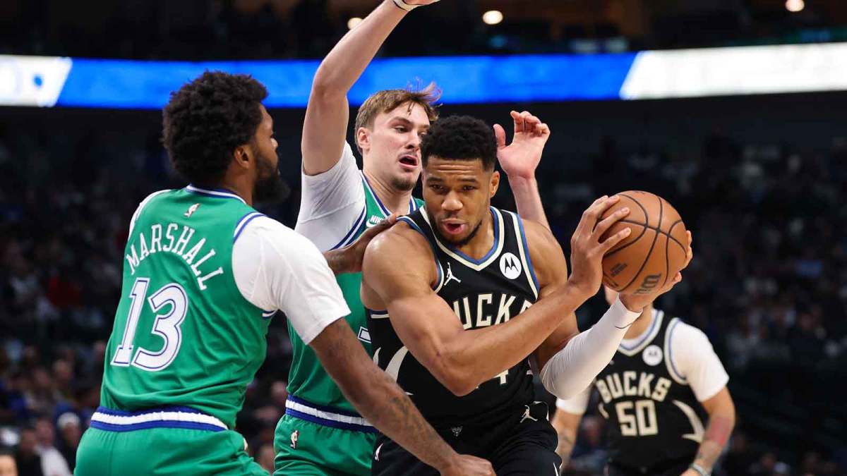 Milwaukee Bucks forward Giannis Antetokounmpo (34) controls the ball as Dallas Mavericks forward Cooper Flagg (32) and Dallas Mavericks forward Naji Marshall (13) defend during the first quarter at American Airlines Center.
