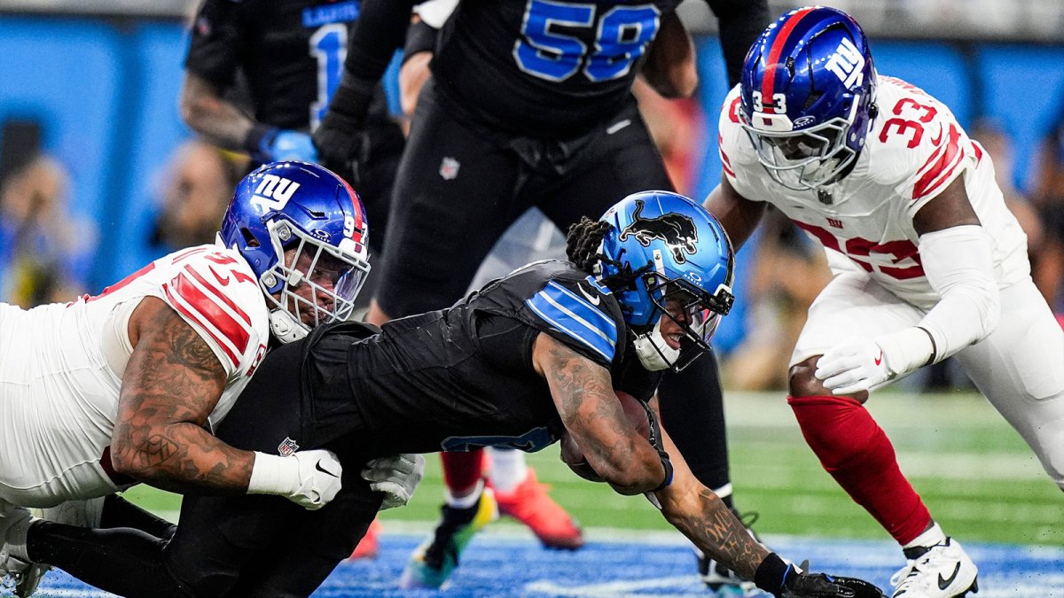 Detroit Lions running back Jahmyr Gibbs (0) runs against New York Giants defensive tackle Dexter Lawrence II (97) and linebacker Demetrius Flannigan-Fowles (33) during the first half at Ford Field in Detroit on Sunday, Nov. 23, 2025.