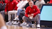 Texas Tech head coach Grant McCasland crouches on the sideline during a non-conference men's basketball game.
