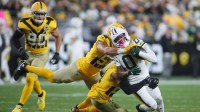 Green Bay Packers wide receiver Matthew Golden (0) gets wrapped up for a tackle by Pittsburgh Steelers linebacker Alex Highsmith (56) and defensive back Chuck Clark (21) during the second half at Acrisure Stadium in Pittsburgh, PA on October 26, 2025.