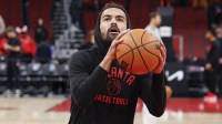 Hawks guard Trae Young (11) warms up before an NBA game against the Chicago Bulls at United Center with NBA announcer Stan Van Gundy in the background