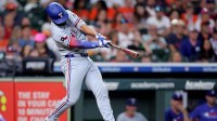Texas Rangers second baseman Marcus Semien (2) hits a home run to left field against the Houston Astros during the eighth inning at Daikin Park.