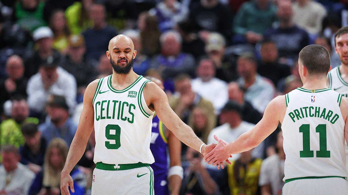 Boston Celtics guard Derrick White (9) slaps hands with Boston Celtics guard Payton Pritchard (11) after being fouled by the Utah Jazz during the fourth quarter at Delta Center.