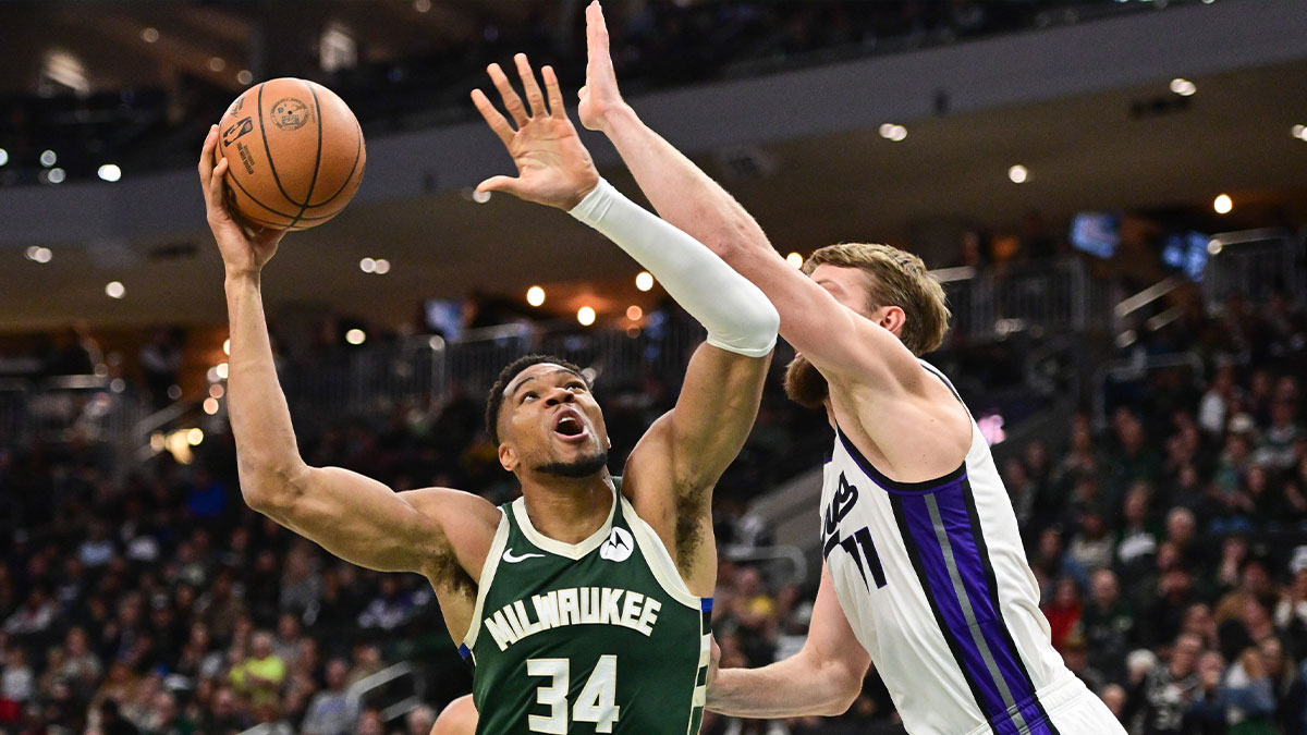 Milwaukee Bucks forward Giannis Antetokounmpo (34) shoots the ball against Sacramento Kings center Domantas Sabonis (11) (obscured) in the second quarter at Fiserv Forum.