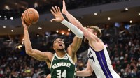 Milwaukee Bucks forward Giannis Antetokounmpo (34) shoots the ball against Sacramento Kings center Domantas Sabonis (11) (obscured) in the second quarter at Fiserv Forum.