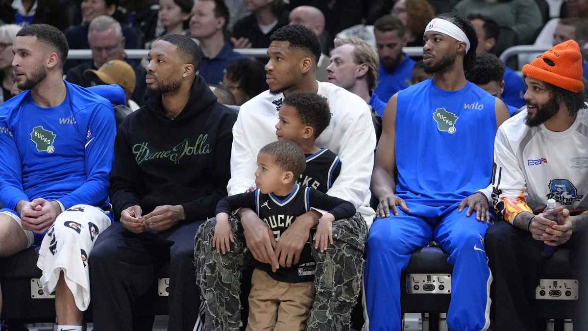 Milwaukee Bucks guard Damian Lillard (0) sits on the bench with Milwaukee Bucks forward Giannis Antetokounmpo (34) and his kids Liam and Maverick during the first half against the Detroit Pistons at American Family Field.