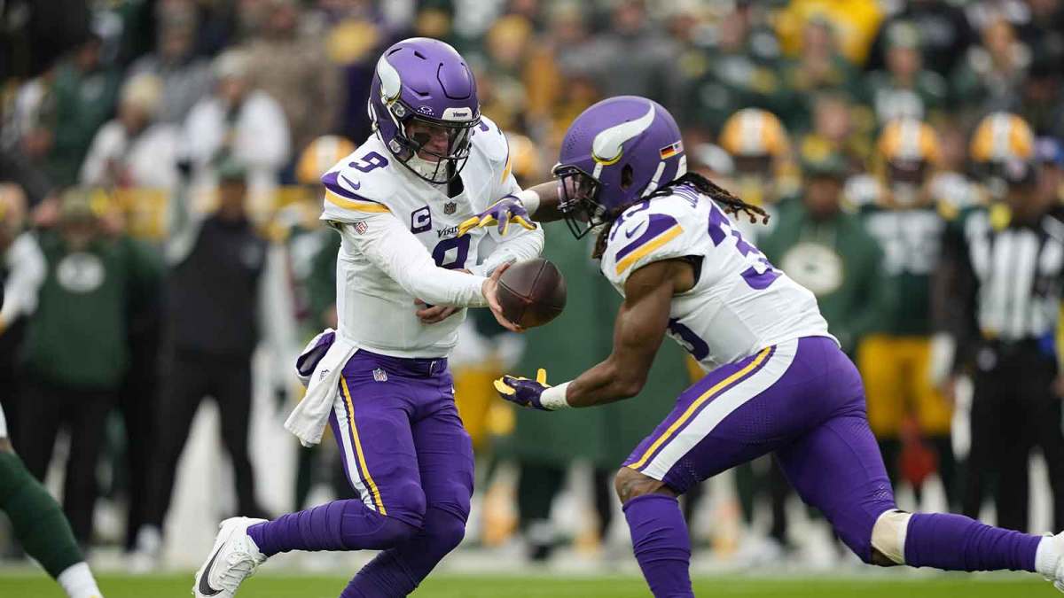 Minnesota Vikings running back Aaron Jones Sr. (33) takes the hand off from quarterback J.J. McCarthy (9) during the first half against the Green Bay Packers at Lambeau Field.