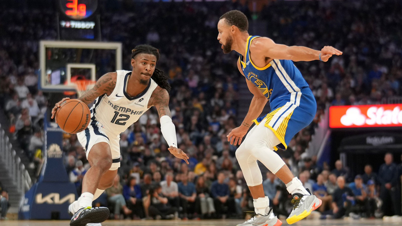 Memphis Grizzlies guard Ja Morant (12) dribbles the ball against Golden State Warriors guard Stephen Curry (30) in the second quarter at the Chase Center.