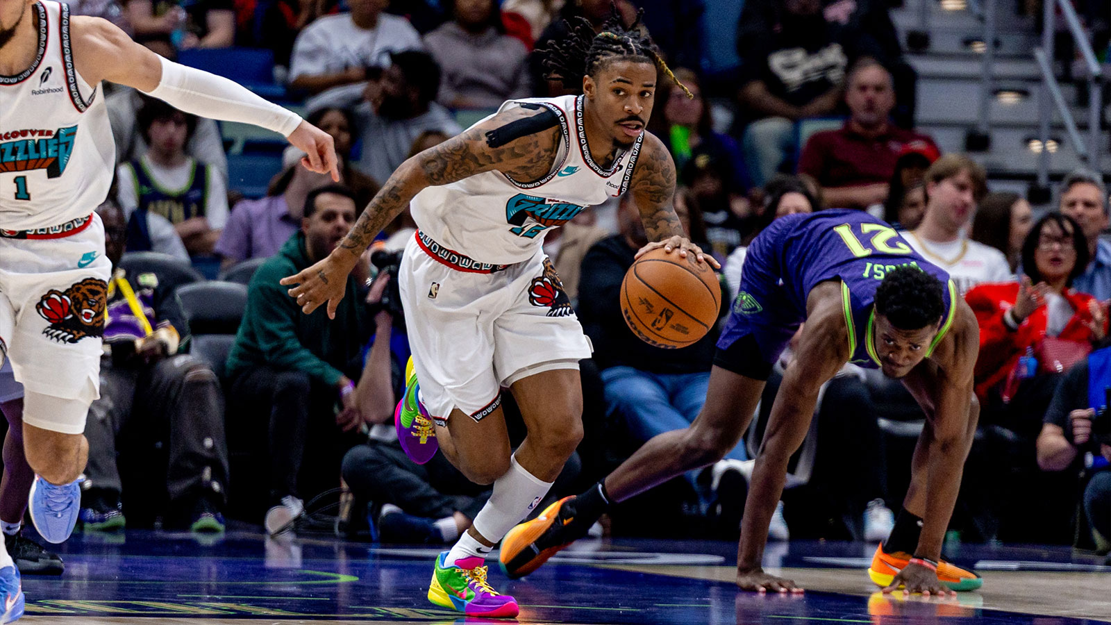 Memphis Grizzlies guard Ja Morant (12) brings the ball up court against New Orleans Pelicans center Yves Missi (21) during the second half at Smoothie King Center. 
