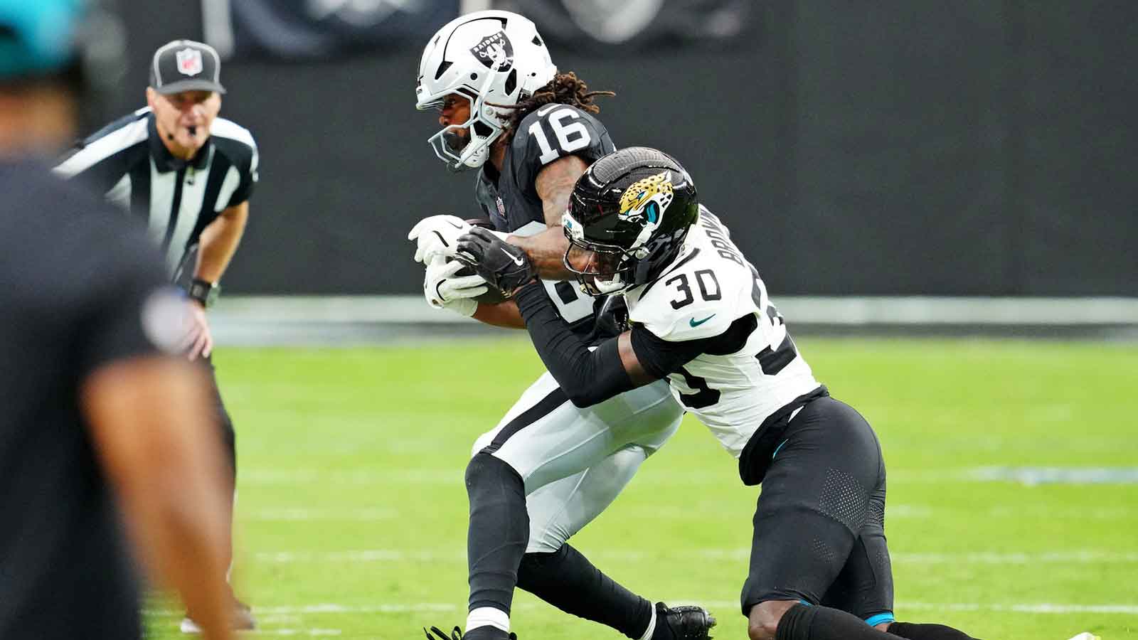 Jacksonville Jaguars cornerback Montaric Brown (30) tackles Las Vegas Raiders wide receiver Jakobi Meyers (16) during the second half at Allegiant Stadium.
