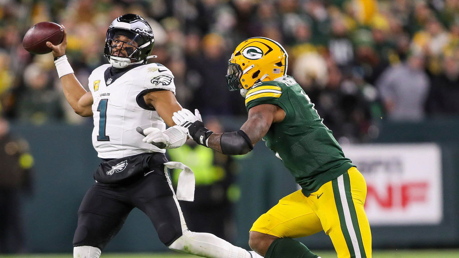 Philadelphia Eagles quarterback Jalen Hurts (1) throws on the run as Green Bay Packers defensive end Micah Parsons closes in on Monday, November 10, 2025, at Lambeau Field in Green Bay, Wis. The Eagles won the game, 10-7. 