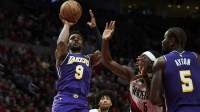 Los Angeles Lakers guard Bronny James (9) shoots a basket during the second half against Portland Trail Blazers guard Jrue Holiday (5) at Moda Center.