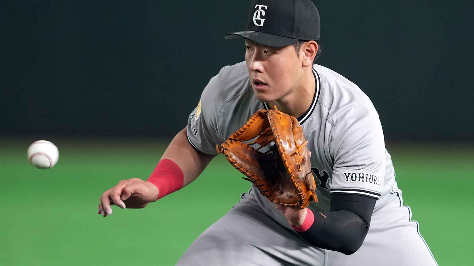 Yomiuri Giants first baseman Kazuma Okamoto (25) fields a ground ball against the Los Angeles Dodgers during the fifth inning at Tokyo Dome.