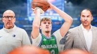 Mavericks Cooper Flagg shooting a free throw in front and middle of image. In background on left, Mavericks Jason Kidd looking serious. In background on right, Mavericks Nico Harrison looking serious.
