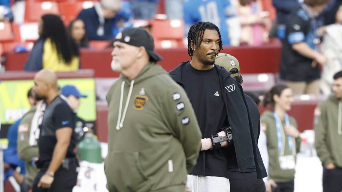 Washington Commanders head coach Dan Quinn stands with quarterback Jayden Daniels (5) on the sidelines during warmups prior to a game against the Detroit Lions at Northwest Stadium.