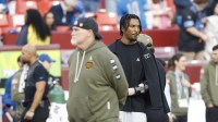 Washington Commanders head coach Dan Quinn stands with quarterback Jayden Daniels (5) on the sidelines during warmups prior to a game against the Detroit Lions at Northwest Stadium.