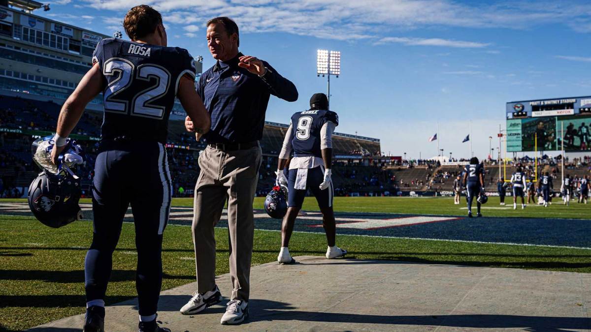 UConn Huskies head coach Jim Mora greets running back Victor Rosa (22) during senior day before the start of the game against the Air Force Falcons at Pratt & Whitney Stadium at Rentschler Field.