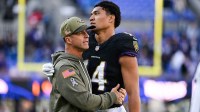 Baltimore Ravens head coach John Harbaugh greets Baltimore Ravens safety Kyle Hamilton (14) on the field after the game against the Chicago Bears at M&T Bank Stadium.