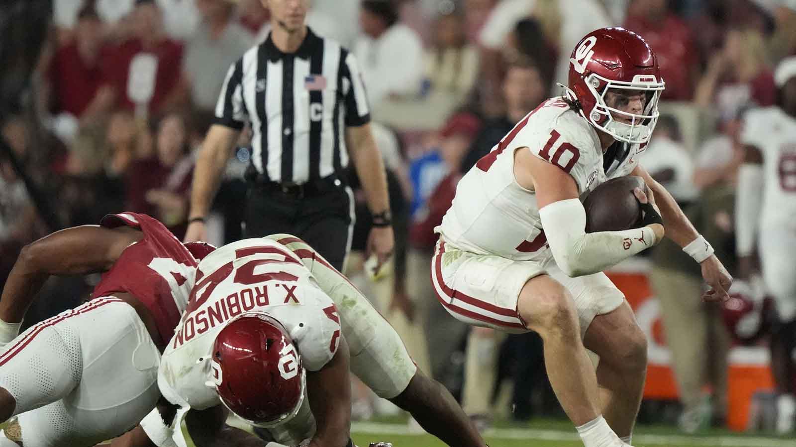 Oklahoma Sooners quarterback John Mateer (10) makes a move as he is pressured by Alabama Crimson Tide linebacker Nikhai Hill-Green (41) at Saban Field at Bryant-Denny Stadium. Oklahoma defeated Alabama 23-21.