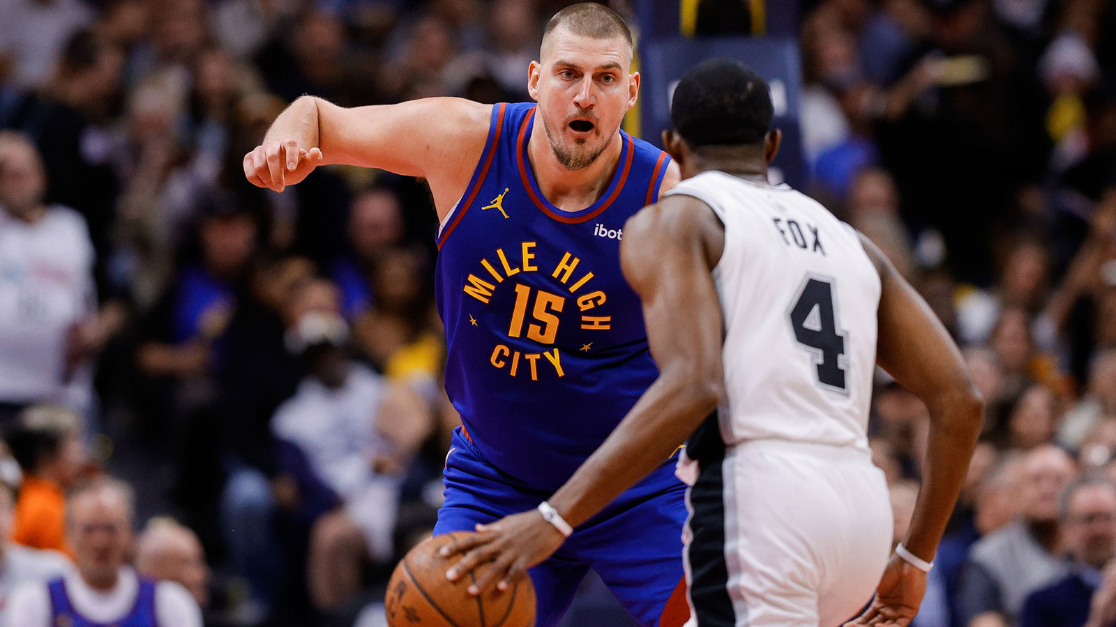 San Antonio Spurs guard De'Aaron Fox (4) controls the ball as Denver Nuggets center Nikola Jokic (15) guards in the second quarter at Ball Arena.