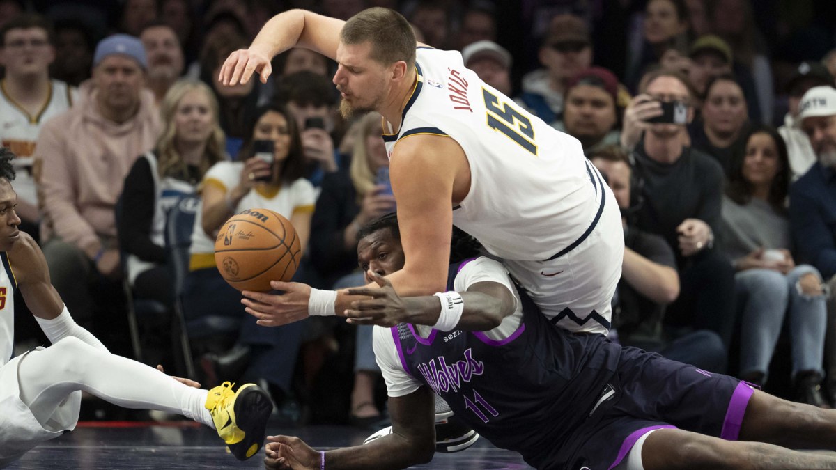 Denver Nuggets center Nikola Jokic (15) and Minnesota Timberwolves center Naz Reid (11) fight for a loose ball in the second half at Target Center.