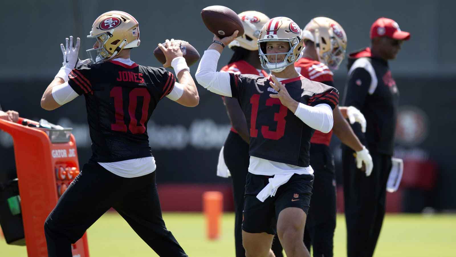 San Francisco 49ers quarterbacks Mac Jones (10) and Brock Purdy (13) work on passing drills during a team OTA at Levi's Stadium. 