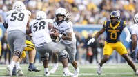 Colorado Buffaloes quarterback Julian Lewis (10) runs out of the pocket during the third quarter against the West Virginia Mountaineers at Milan Puskar Stadium.