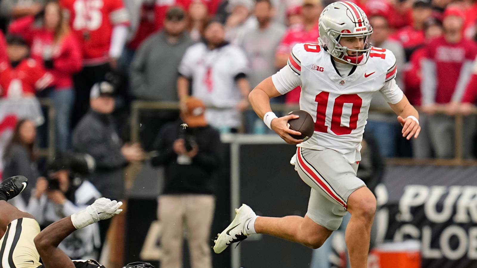 Ohio State Buckeyes quarterback Julian Sayin (10) runs past Purdue Boilermakers defensive lineman CJ Nunnally (91) during the NCAA football game at Ross-Ade Stadium in West Lafayette, Ind. on Nov. 8, 2025. Ohio State won 34-10.