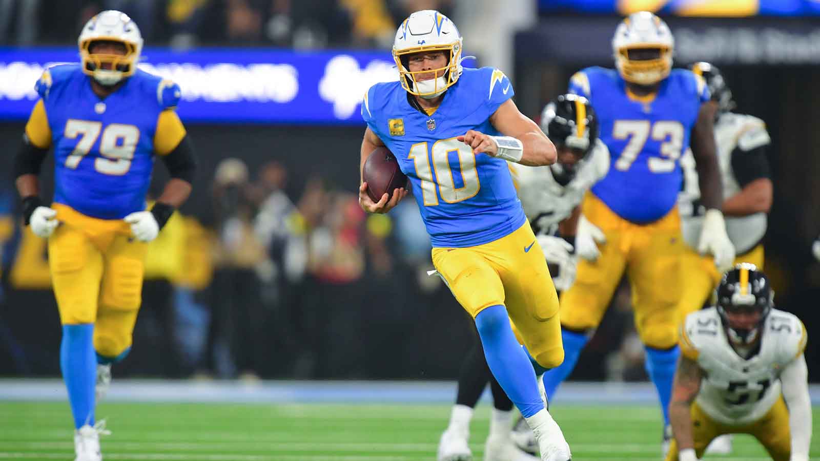 Los Angeles Chargers quarterback Justin Herbert (10) scrambles with the ball against the Pittsburgh Steelers during the third quarter of the game at SoFi Stadium.