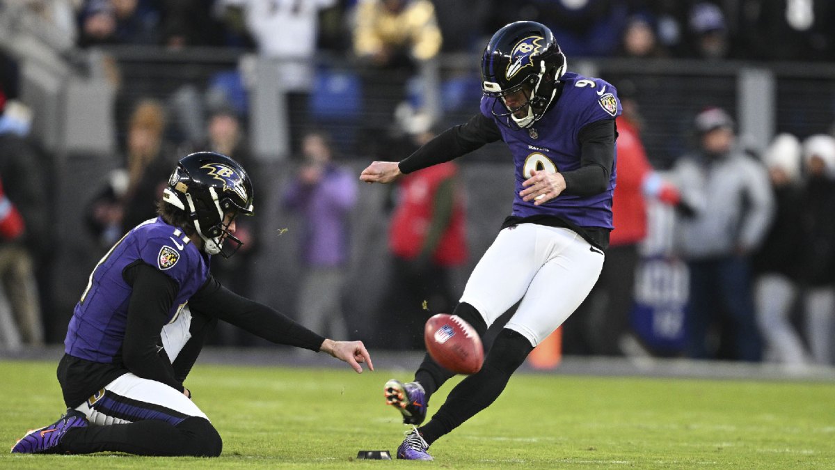 Baltimore Ravens place kicker Justin Tucker (9) kicks off as punter Jordan Stout (11) holds during the first quarter against the Cleveland Browns at M&T Bank Stadium.