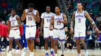 Kansas Jayhawks guard Melvin Council Jr. (14), forward Bryson Tiller (15), forward Flory Bidunga (40), guard Elmarko Jackson (13) and guard Tre White (3) walk back onto the court after a timeout against the Notre Dame Fighting Irish during the first half in a 2025 Players Era Festival group play game at MGM Grand Garden Arena.
