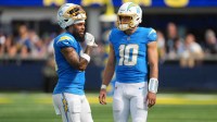 Los Angeles Chargers quarterback Justin Herbert (10) talks with wide receiver Keenan Allen (13) against the Los Angeles Rams in the first half at SoFi Stadium.