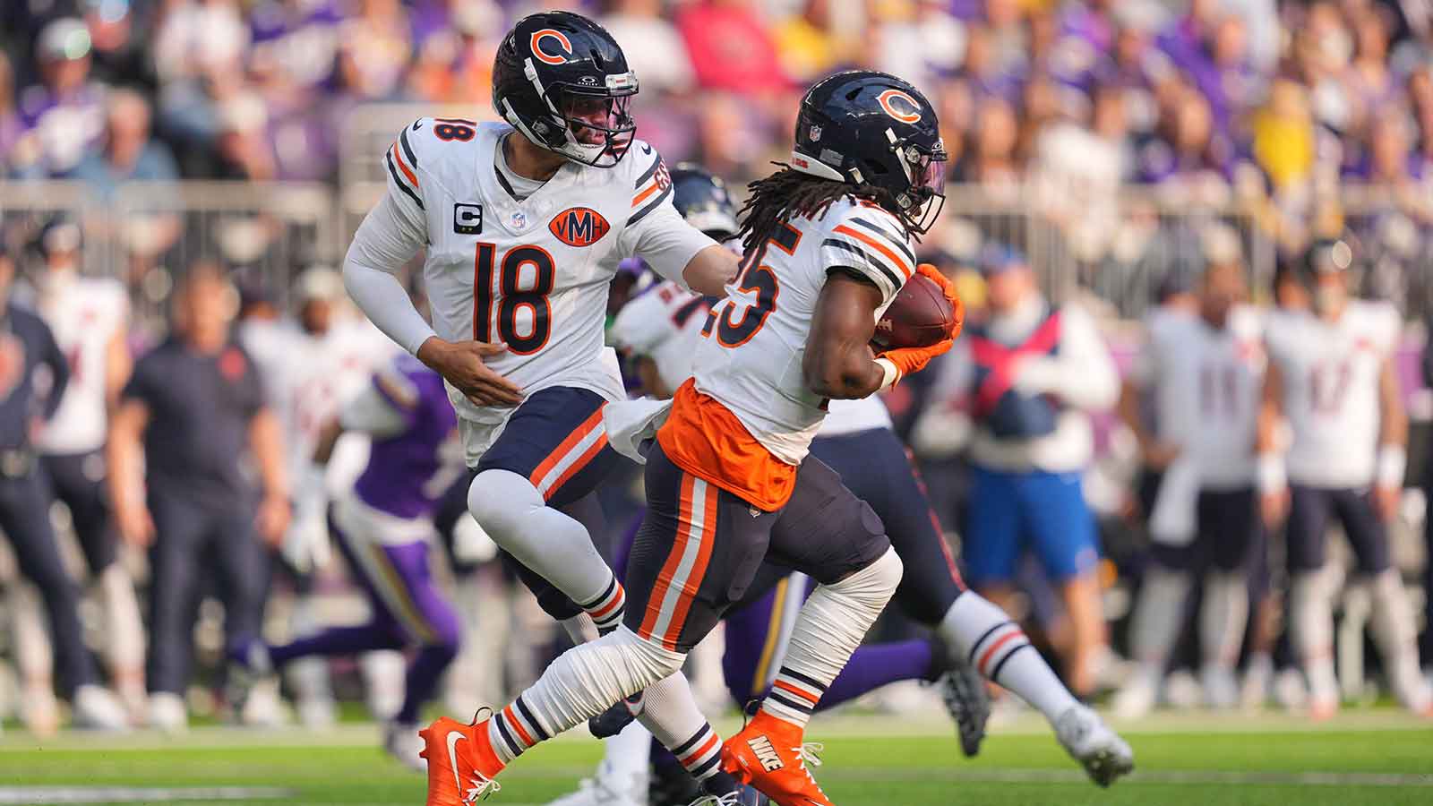 Chicago Bears quarterback Caleb Williams (18) hands the ball off to running back Kyle Monangai (25) during the first quarter against the Minnesota Vikings at U.S. Bank Stadium. 