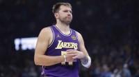 Lakers guard Luka Doncic reacts to a fan during the second quarter of a game against the Oklahoma City Thunder at Paycom Center with former Mavericks GM Nico Harrison in the background