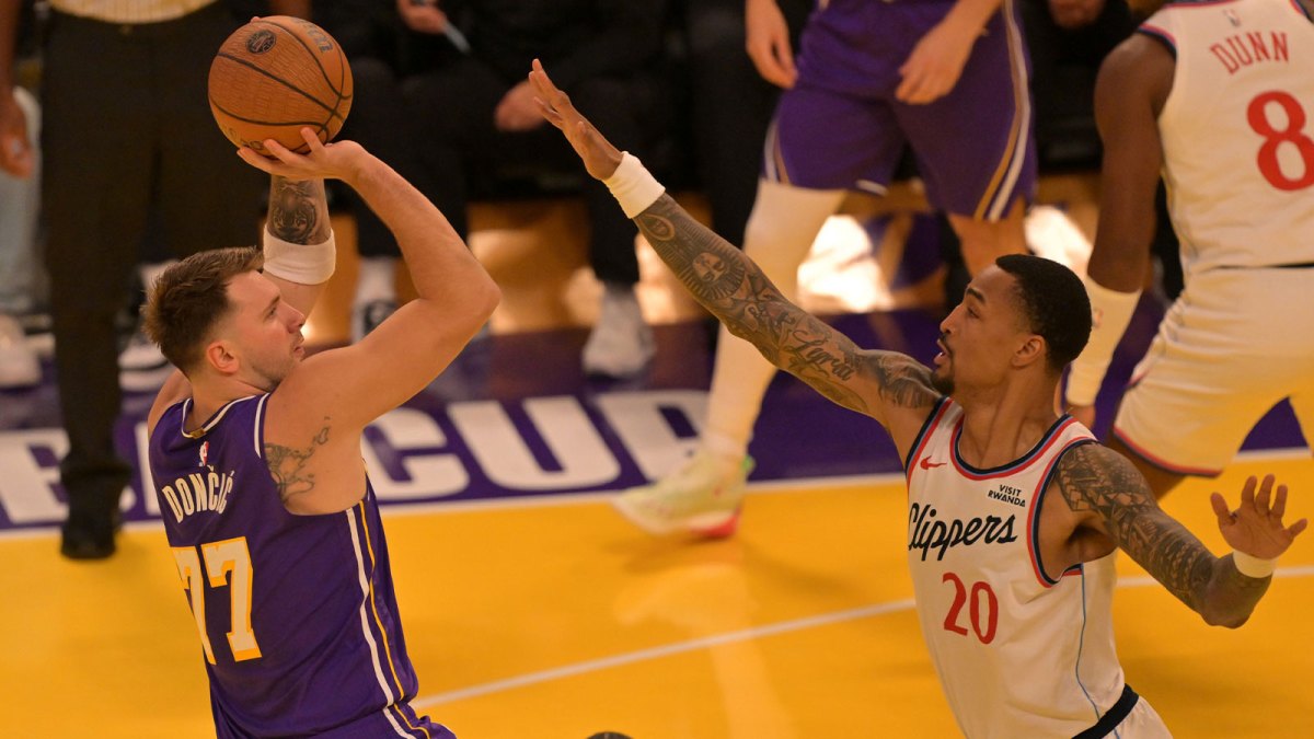 Los Angeles Lakers guard Luka Doncic (77) shoots over Los Angeles Clippers forward John Collins (20) during the first half at Crypto.com Arena.