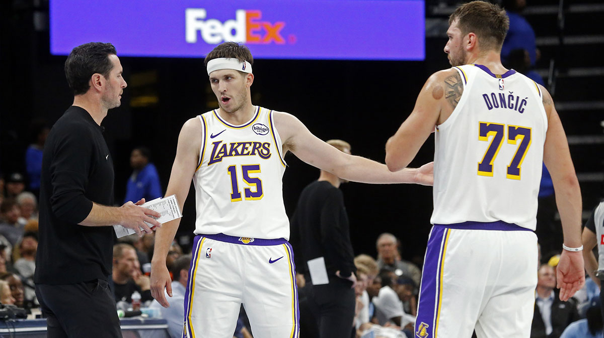 Lakers head coach JJ Redick talks with guard Austin Reaves (15) and guard Luka Doncic (77) during the fourth quarter against the Memphis Grizzlies at FedExForum