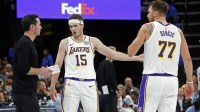 Lakers head coach JJ Redick talks with guard Austin Reaves (15) and guard Luka Doncic (77) during the fourth quarter against the Memphis Grizzlies at FedExForum