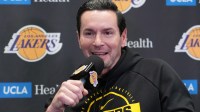 Lakers head coach JJ Redick at press conference at Crypto.com Arena with Clippers' Chris Paul in the background